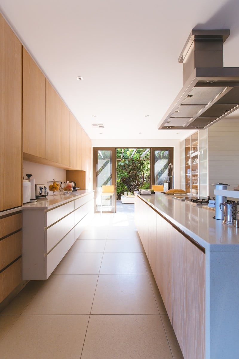 white wooden kitchen island and cupboard cabinets near glass panel door